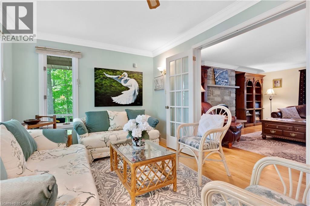 Living area featuring wood-finish flooring, crown molding, a large window, and French doors - 110 Grand Ridge Drive, Cambridge, ON