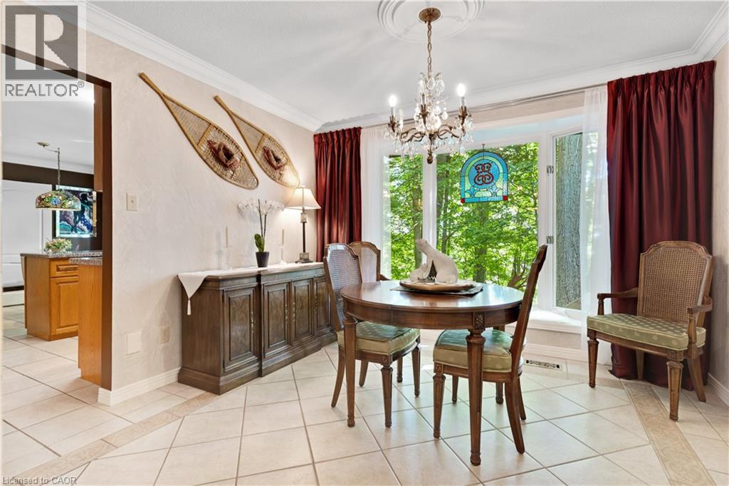 Formal dining area featuring a bay window, decorative chandelier, and crown molding - 110 Grand Ridge Drive, Cambridge, ON