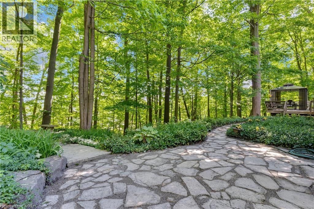 Stone pathway with lush landscaping and mature trees - 110 Grand Ridge Drive, Cambridge, ON