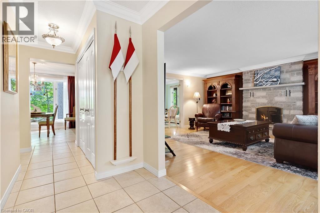 Welcoming entryway with tile flooring and a view into the dining area, featuring a decorative chandelier and outdoor greenery - 110 Grand Ridge Drive, Cambridge, ON