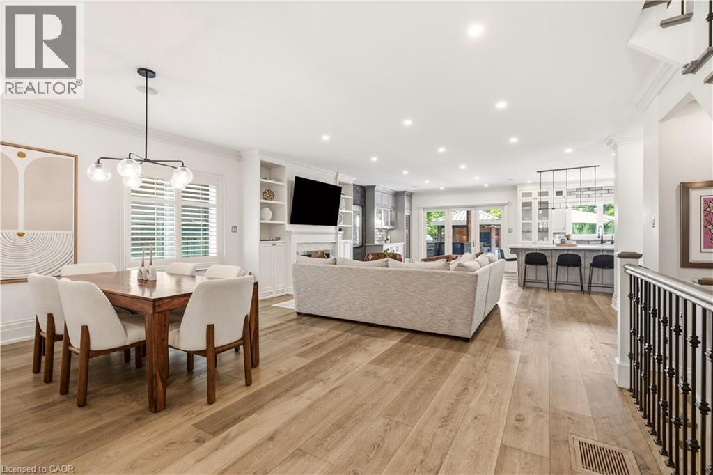 Expansive open-concept living area featuring wood-finish flooring, recessed lighting, and a contemporary chandelier - 336 Newbold Court, Burlington, ON