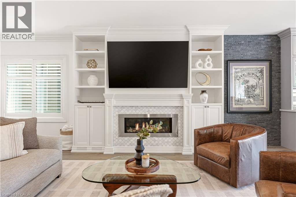 Integrated media wall featuring built-in white cabinetry and shelving - 336 Newbold Court, Burlington, ON