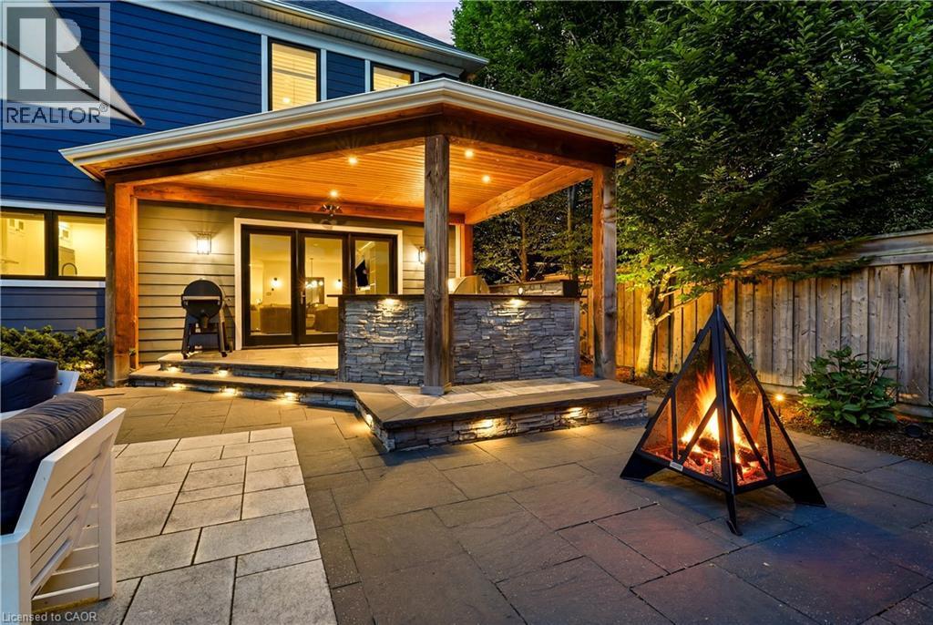 Covered patio featuring a wood-finish ceiling with recessed lighting and substantial wood columns - 336 Newbold Court, Burlington, ON