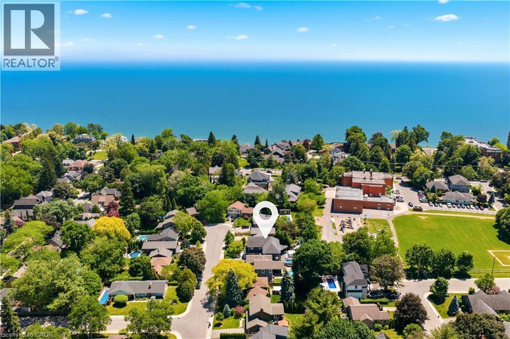 Aerial perspective showcasing a residential neighborhood with ample tree cover, surrounded by a large body of water - 336 Newbold Court, Burlington, ON