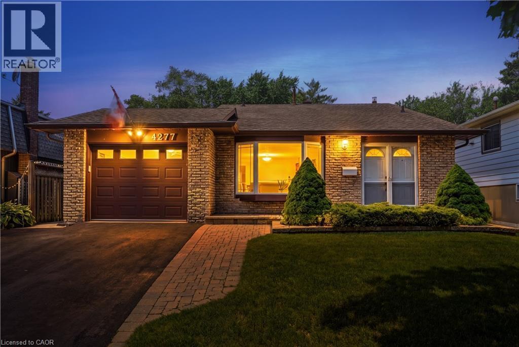 Stone-clad facade featuring a single-car garage with a paneled door - 4277 Longmoor Drive, Burlington, ON