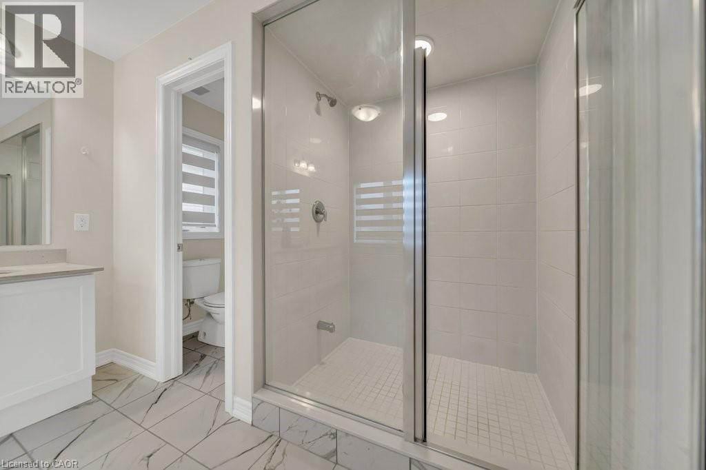 Full bathroom featuring a stall shower, vanity, and light marble finish floors - 285 Broadacre Drive, Kitchener, ON