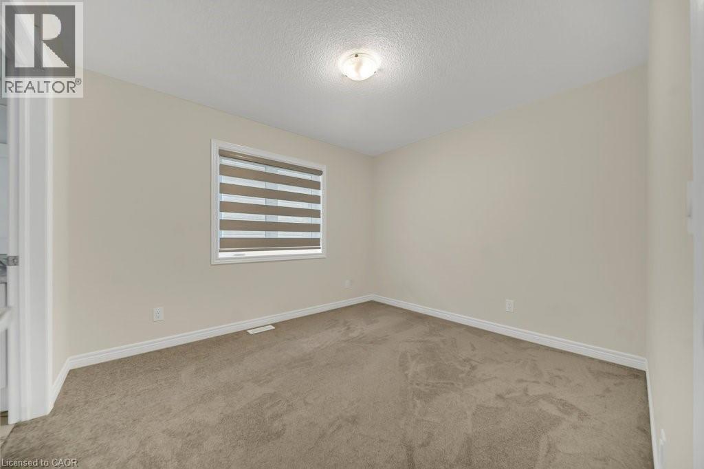 Empty room with a textured ceiling and light carpet - 285 Broadacre Drive, Kitchener, ON