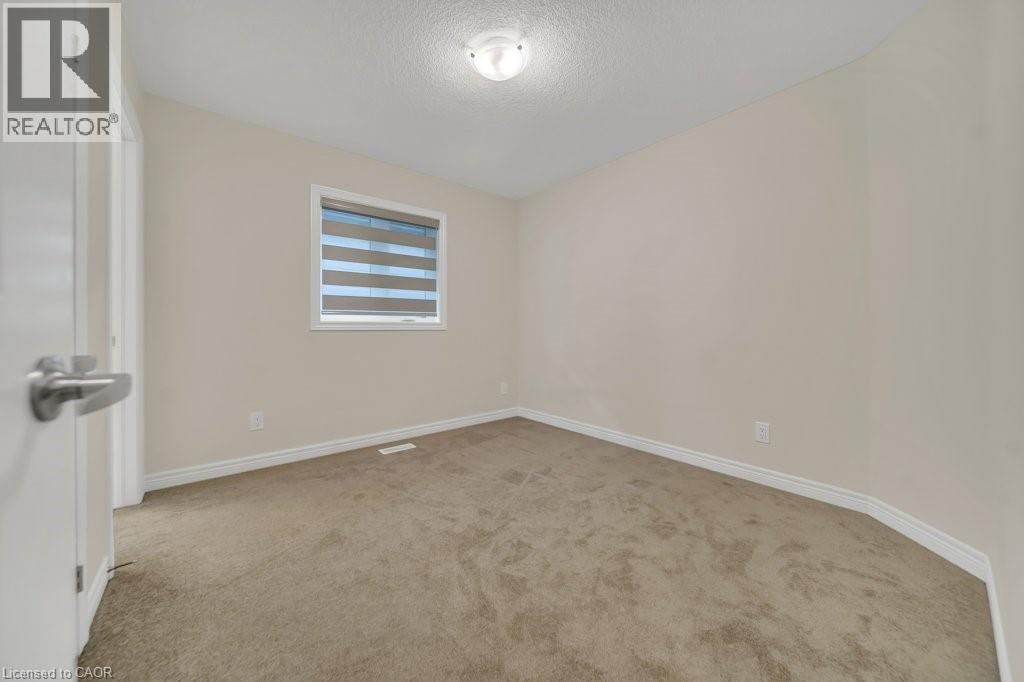Unfurnished room with light carpet and a textured ceiling - 285 Broadacre Drive, Kitchener, ON