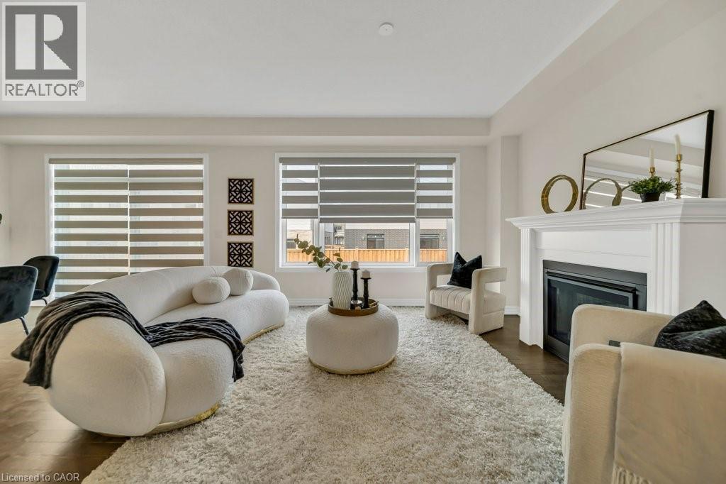 Living room featuring dark wood-style floors and a glass covered fireplace - 285 Broadacre Drive, Kitchener, ON