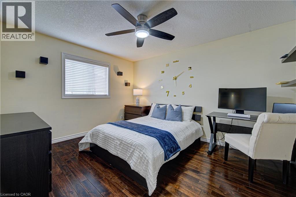 Bedroom featuring wood-finish flooring, a window with blinds, and a ceiling fan with integrated lighting - 37 Davinci Boulevard, Hamilton, ON