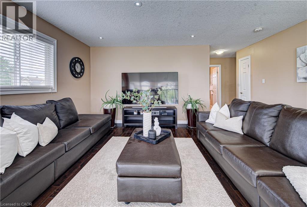 Living area featuring wood-finish flooring, recessed lighting, and a neutral wall color - 37 Davinci Boulevard, Hamilton, ON