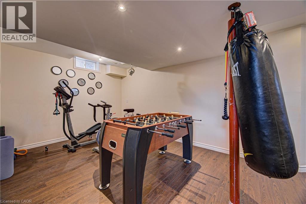 Finished basement space with wood-finish flooring, recessed lighting, and a window for natural light - 37 Davinci Boulevard, Hamilton, ON
