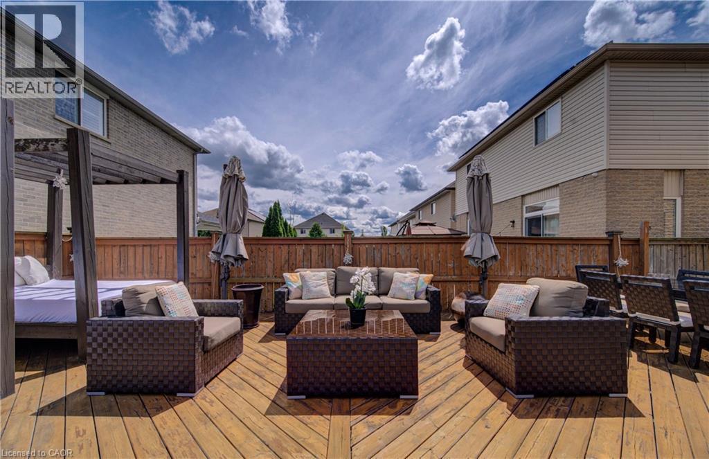Expansive wood deck featuring a perimeter privacy fence, integrated outdoor seating areas, and a structured daybed - 37 Davinci Boulevard, Hamilton, ON