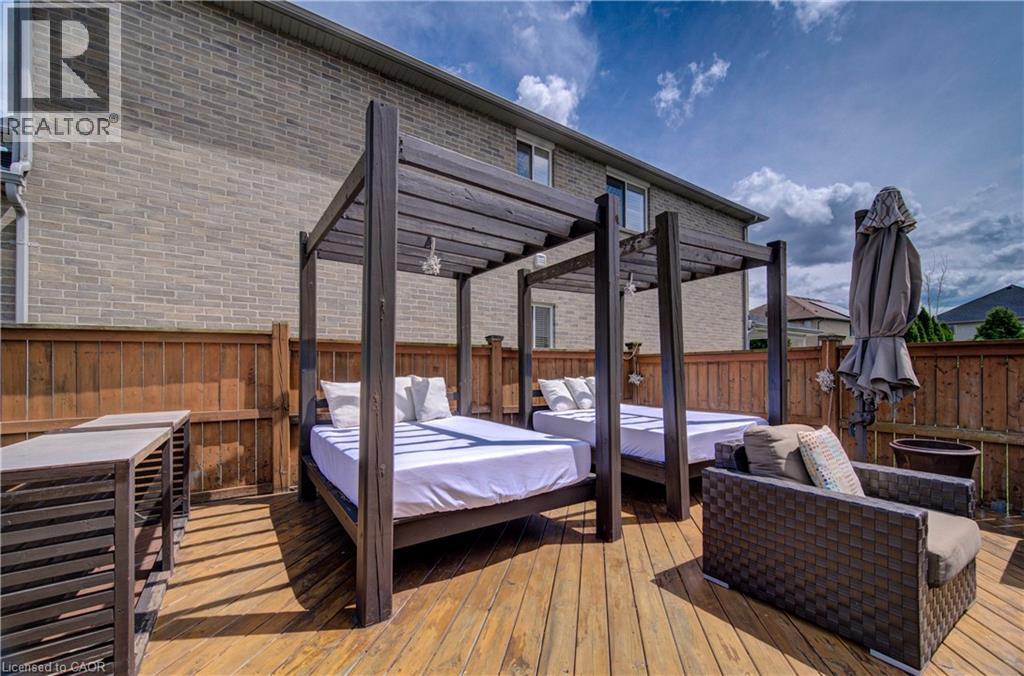 Expansive wood-finish deck with two pergola-style daybeds and a perimeter wood fence - 37 Davinci Boulevard, Hamilton, ON