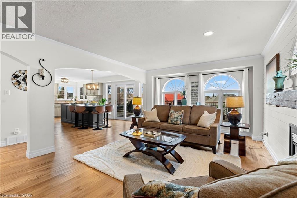 Living area featuring wood-finish flooring, recessed lighting, and a white shiplap-paneled accent wall with a built-in fireplace - 26 Shadyridge Place, Kitchener, ON