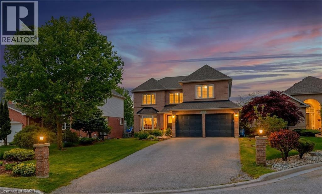 Brick-clad residence featuring a two-car garage, bay window, and a paved driveway - 26 Shadyridge Place, Kitchener, ON
