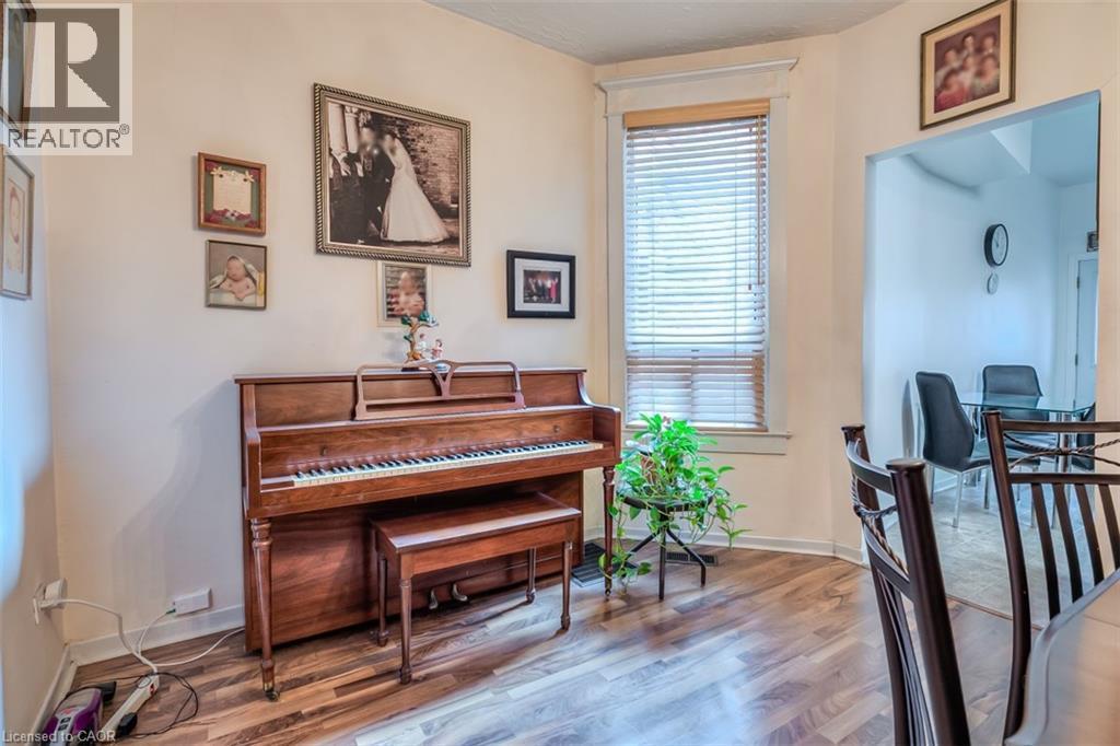 Wood-finish flooring throughout, featuring a window with horizontal blinds and a cased opening to an additional room - 41 Springhurst Avenue, Toronto, ON