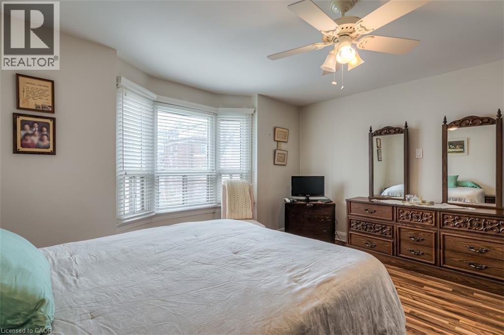 Bedroom featuring a bay window with blinds, wood-finish flooring, and a ceiling fan with integrated lighting - 41 Springhurst Avenue, Toronto, ON