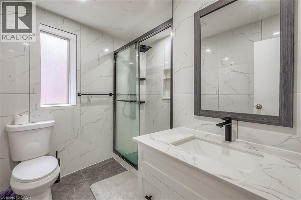 Contemporary bathroom featuring a white vanity with integrated sink, a framed mirror, and a walk-in shower with glass enclosure - 41 Springhurst Avenue, Toronto, ON