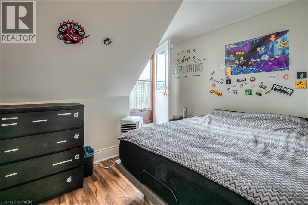 Sloped ceiling room featuring wood-finish flooring, a white interior door, and light-toned walls - 41 Springhurst Avenue, Toronto, ON