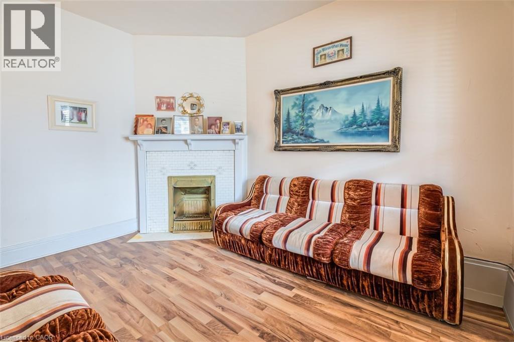 Interior space featuring wood-finish flooring, a white mantel, and fireplace surround with white square tiling - 41 Springhurst Avenue, Toronto, ON