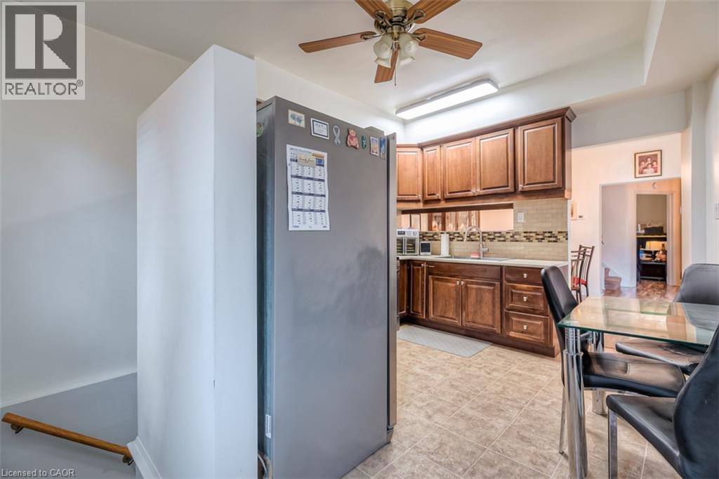 Kitchen featuring wood cabinetry, light countertops, and a tiled backsplash - 41 Springhurst Avenue, Toronto, ON