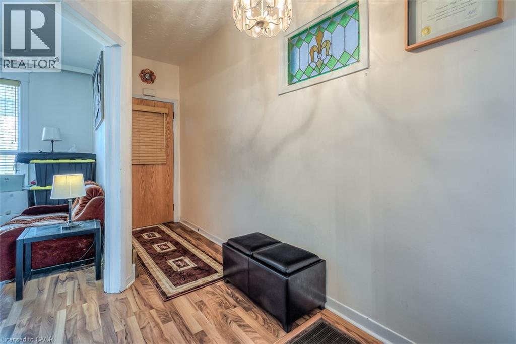Entryway featuring wood-finish flooring, a wood door with horizontal blinds, and a decorative stained-glass window - 41 Springhurst Avenue, Toronto, ON