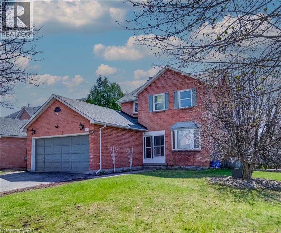 Brick exterior featuring a two-car garage, bay window, and gabled roofline - 27 Tassie Lane, Cambridge, ON