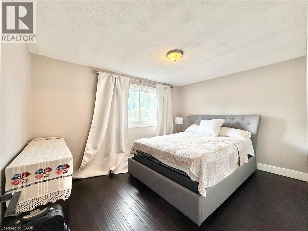 Room featuring wood-finish flooring, neutral wall tones, and a window with white drapery - 3135 Palmer Drive, Burlington, ON