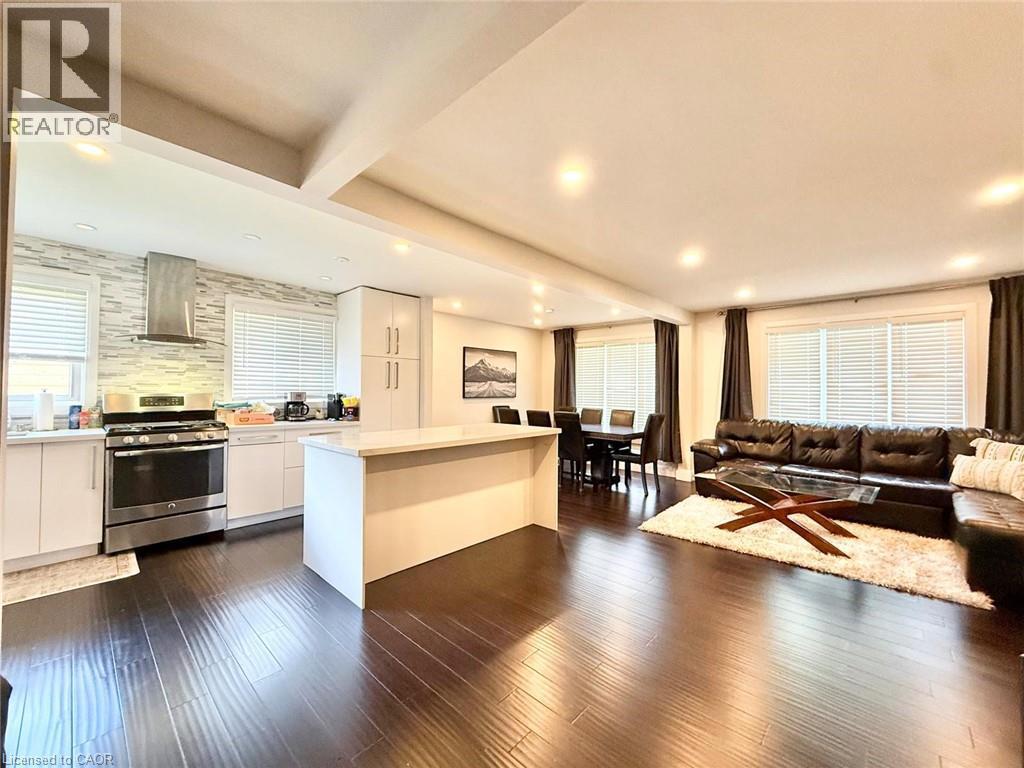 Open-concept living area featuring dark wood-finish flooring throughout - 3135 Palmer Drive, Burlington, ON