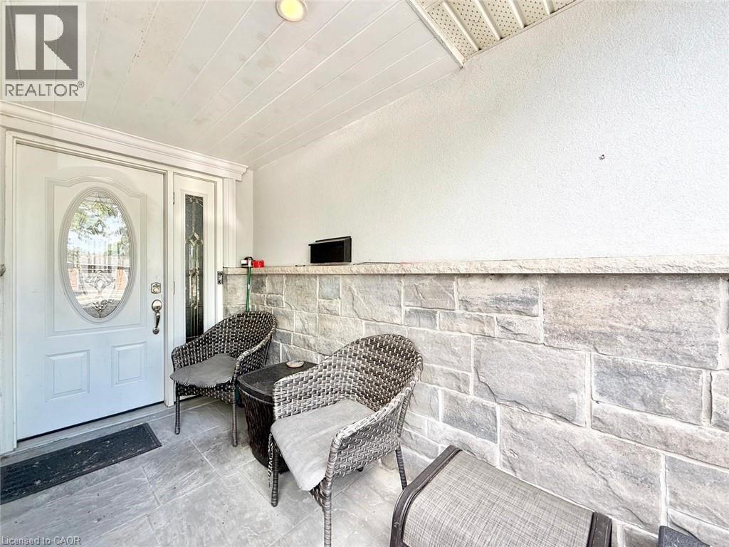 Front entry with a white door featuring an oval decorative glass insert and a sidelight with stained glass - 3135 Palmer Drive, Burlington, ON