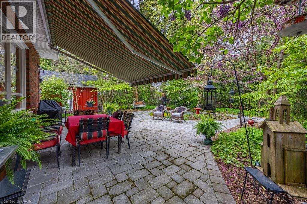 Interlocking brick patio that wraps around the beautiful backyard perennial gardens - 72 Crescent Boulevard, Simcoe, ON - Outdoor With Deck Patio Veranda