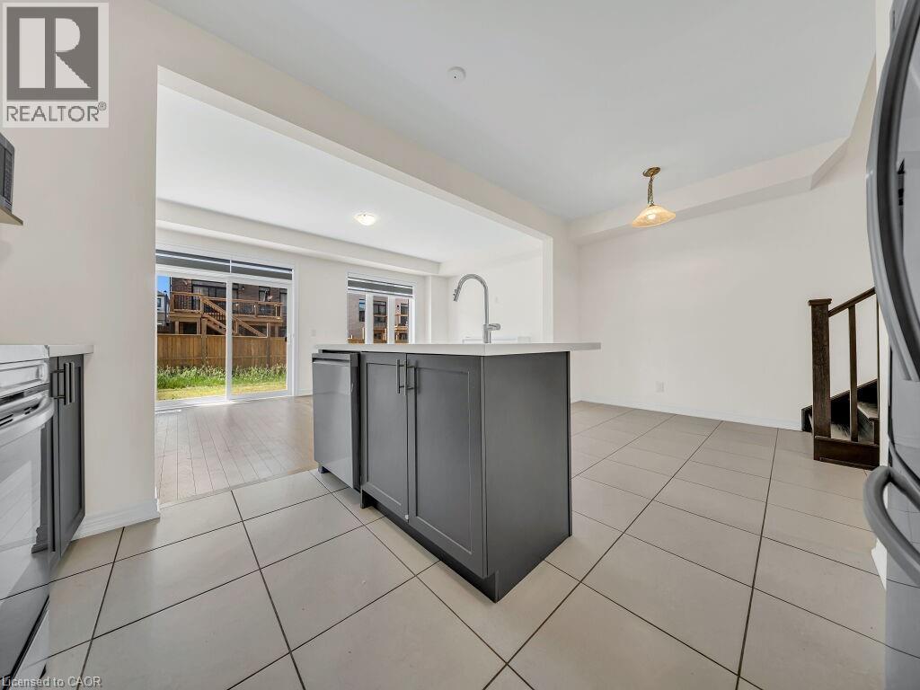 Kitchen island with an undermount sink, a gooseneck faucet, and integrated cabinetry - 76 Grassbourne Avenue, Kitchener, ON