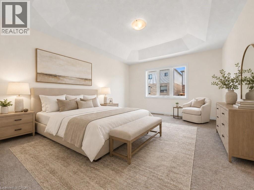 Spacious bedroom featuring a tray ceiling, carpeted flooring, and a large window - 76 Grassbourne Avenue, Kitchener, ON
