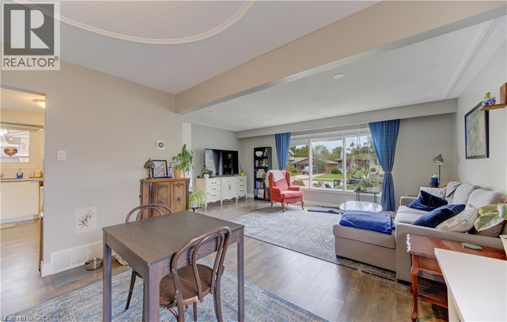 Bright living area featuring wood-finish flooring, a large picture window, and recessed lighting - 127 Strathcona Crescent, Kitchener, ON