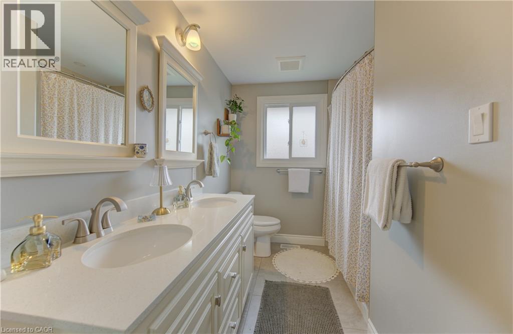 Bathroom featuring a double vanity with an integrated countertop and two undermount sinks - 127 Strathcona Crescent, Kitchener, ON
