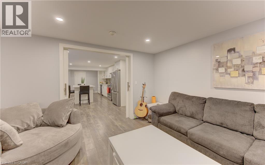 Recessed lighting illuminates this room featuring light gray walls and wood-finish flooring - 127 Strathcona Crescent, Kitchener, ON