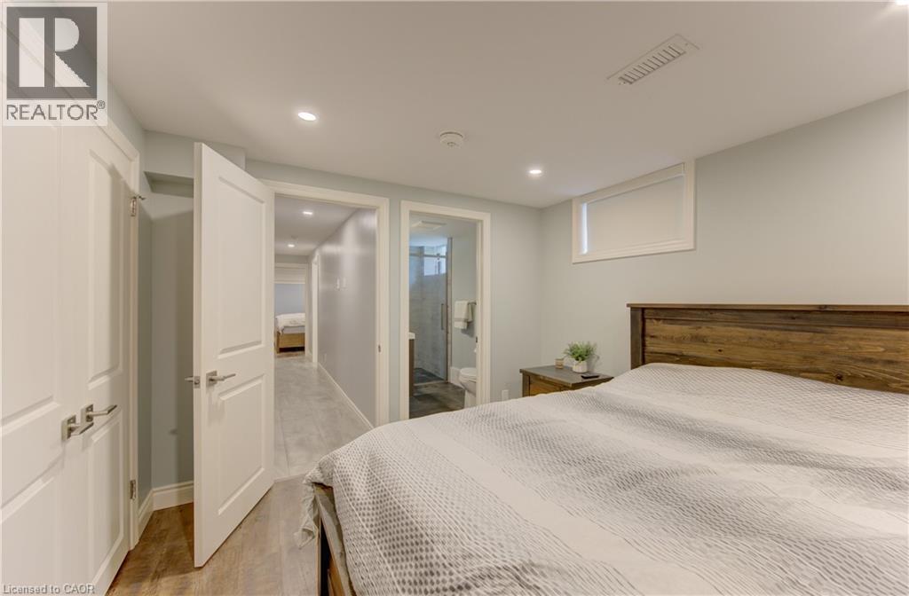 Bedroom featuring recessed lighting, a high window, wood-finish flooring, and two paneled interior doors - 127 Strathcona Crescent, Kitchener, ON