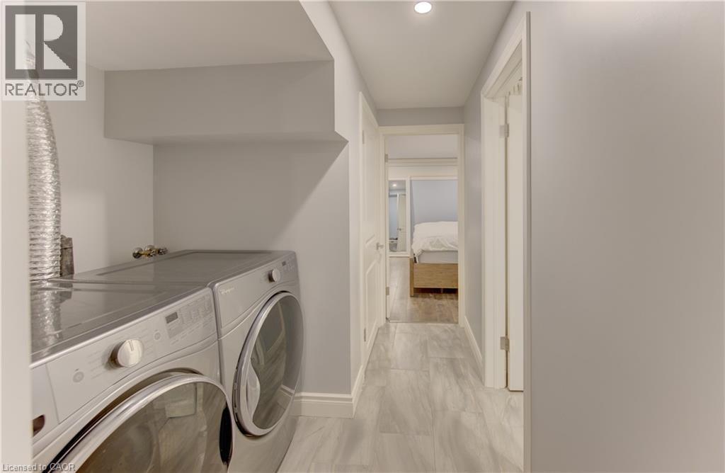 Dedicated laundry area featuring a front-loading washer and dryer set - 127 Strathcona Crescent, Kitchener, ON
