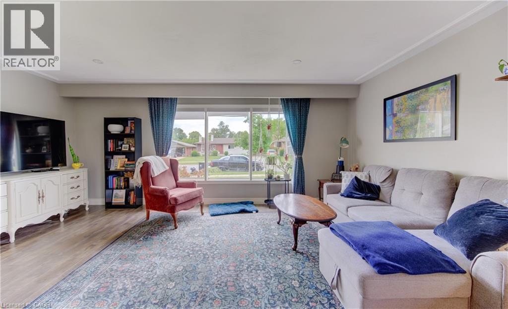 Expansive living area featuring wood-finish flooring, a large picture window, crown molding, and recessed lighting - 127 Strathcona Crescent, Kitchener, ON