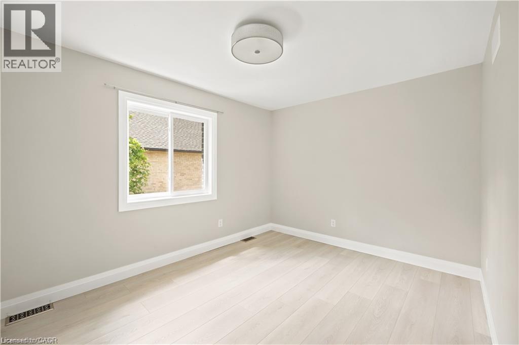 Bright room featuring light-toned walls and wood-finish flooring - 129 St George Street, Kitchener, ON