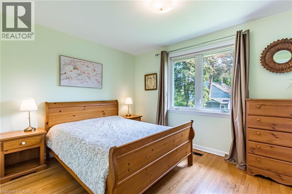 Bedroom featuring hardwood flooring, a large window, a ceiling-mounted light fixture, and light-toned wall paint - 1293 Daimler Road, Mississauga, ON - Indoor Photo Showing Bedroom