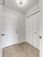 Entryway featuring light-toned tile flooring, a paneled entry door, and bi-fold closet doors -