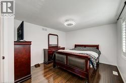 Bright interior space featuring wood-finish flooring, white walls, and a contemporary ceiling light fixture -