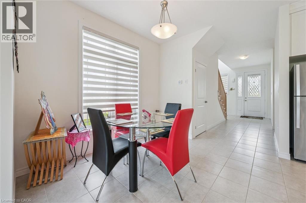 Open-concept dining area featuring light-toned tile flooring and a contemporary pendant light fixture - 153 Rivertrail Avenue, Kitchener, ON - Indoor Photo Showing Dining Room