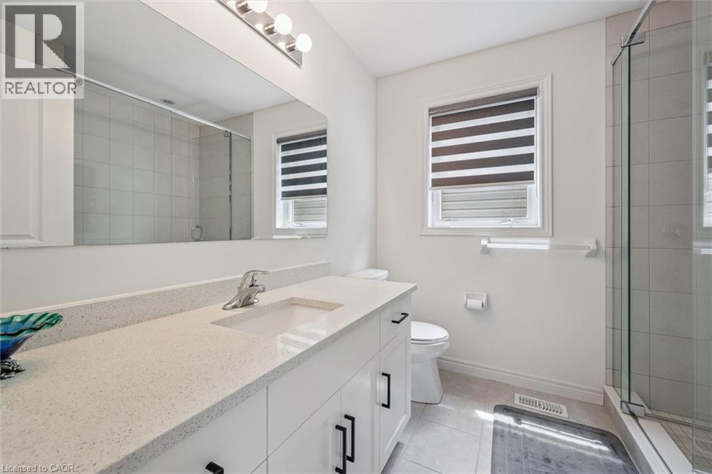 Bathroom featuring a vanity with an integrated sink, a speckled countertop, and white cabinetry with black hardware - 153 Rivertrail Avenue, Kitchener, ON - Indoor Photo Showing Bathroom