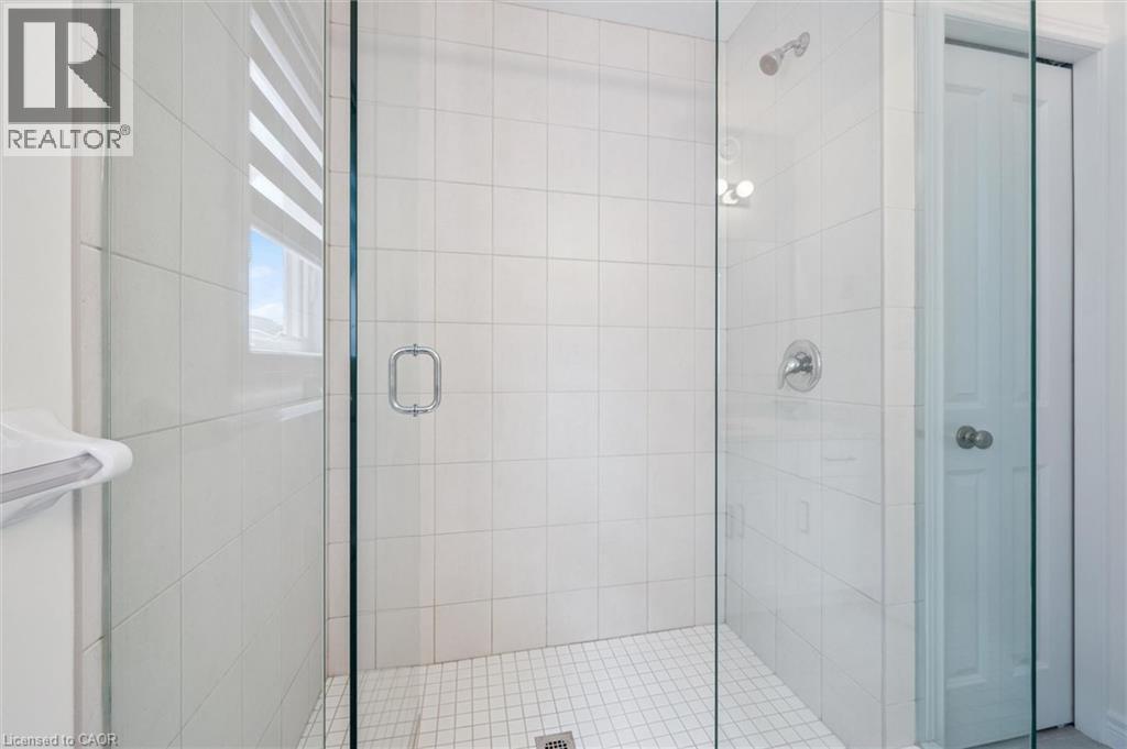 Glass-enclosed shower featuring white wall tiling, a tiled floor, and chrome fixtures - 153 Rivertrail Avenue, Kitchener, ON - Indoor Photo Showing Bathroom