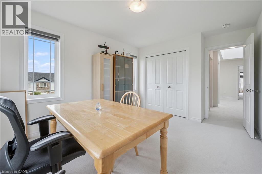 Bright room featuring a window with a roller shade, light-toned wall-to-wall carpeting, and a built-in bi-fold closet - 153 Rivertrail Avenue, Kitchener, ON - Indoor Photo Showing Dining Room