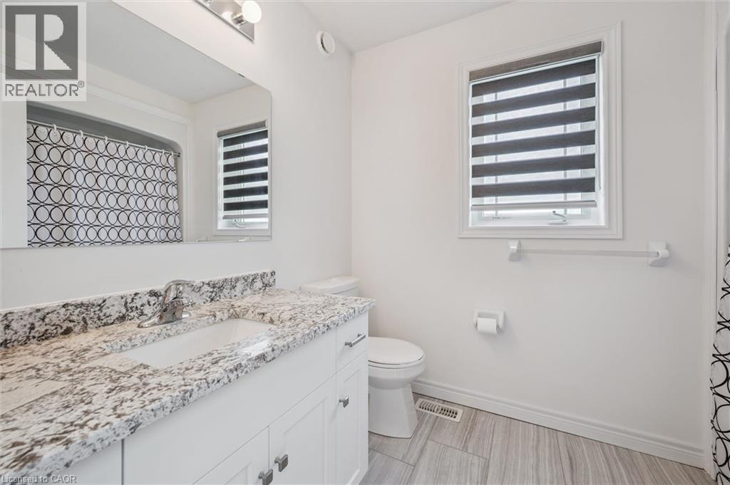 Bathroom featuring a white vanity with a patterned countertop and an undermount sink - 153 Rivertrail Avenue, Kitchener, ON - Indoor Photo Showing Bathroom