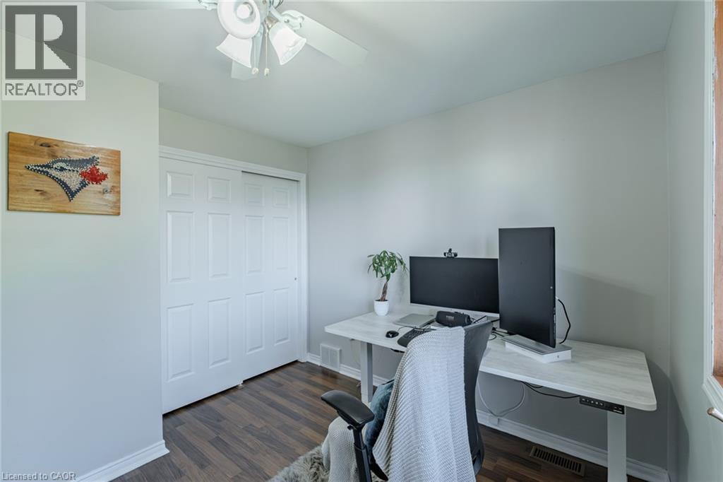 Room featuring wood-finish flooring, light grey painted walls, and a white ceiling fan - 141 Lynndale Road, Simcoe, ON